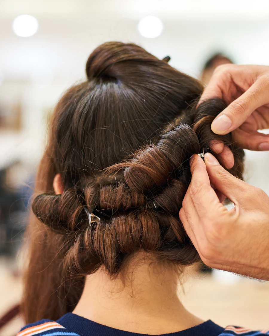 Handen die haar opsteken met schuifspelden
